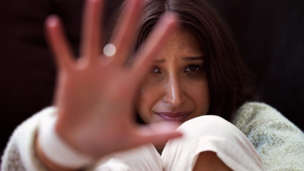 Shot of a young woman looking distressed and reading out her hand.