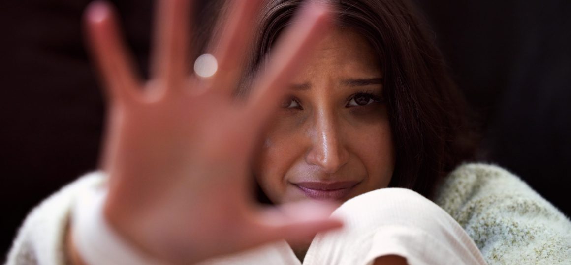 Shot of a young woman looking distressed and reading out her hand.