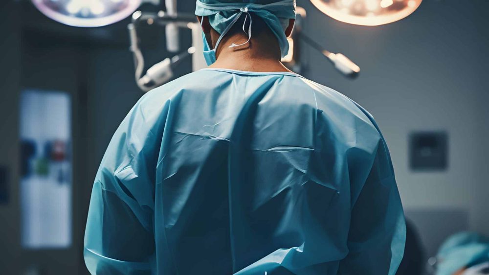 Doctor ready to perform surgery on patient in operating room, back view photo