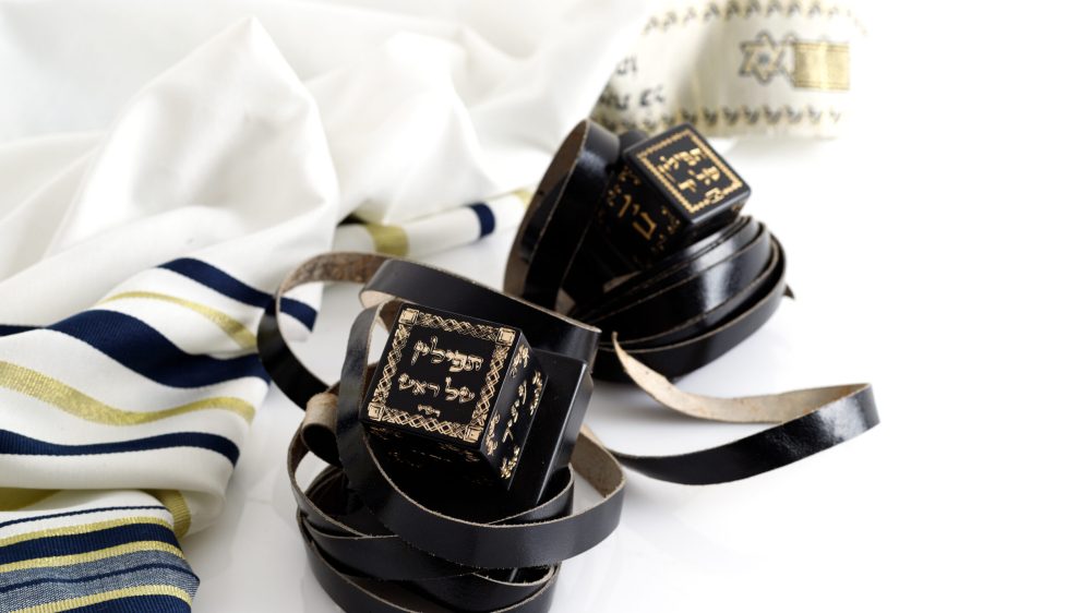 Tallit and tefillin on white background