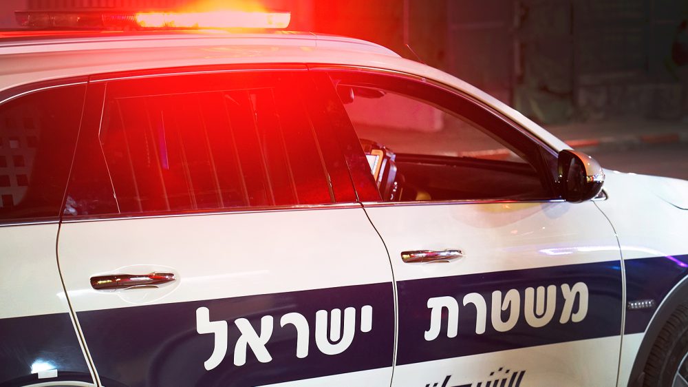 Israeli police car. The inscription on the door of the car is in Hebrew and in Arabic. Israeli police car with text and logo close-up. Close-up of the red lights on top of a Israeli police vehicle. Night time. 2 May 2018. Tel Aviv. Israel